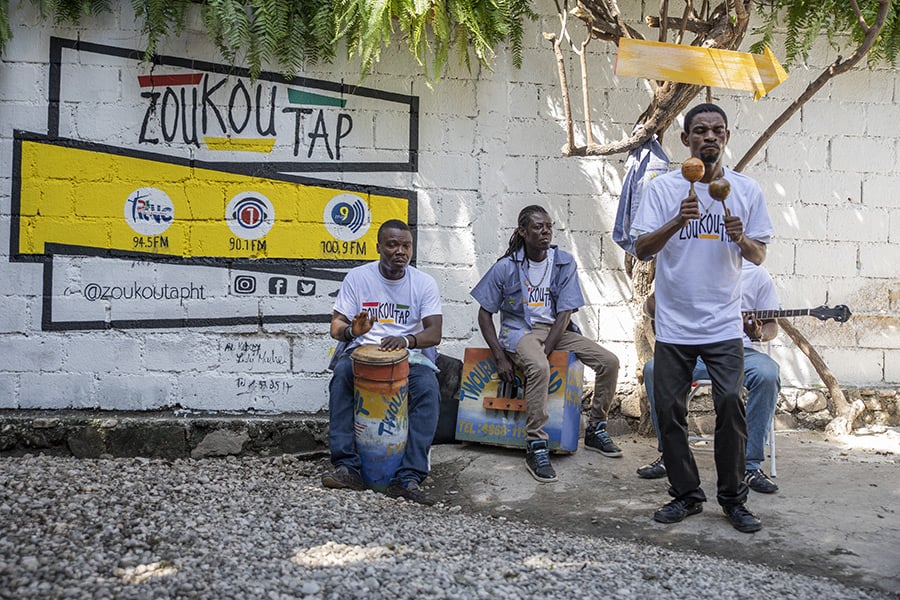 Musicians in Zoukoutap shirts playing in front of Zoukoutap mural