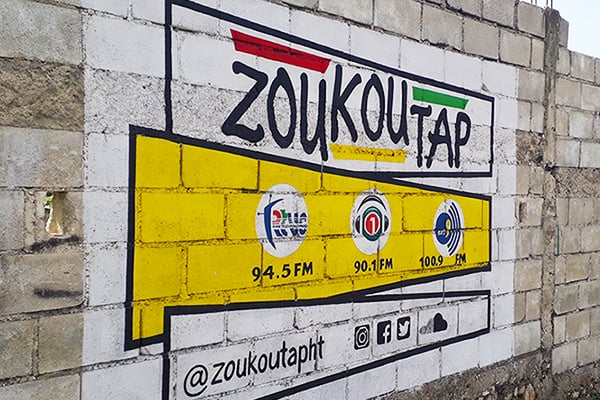 Zoukoutap mural with logo, radio stations, and social media links