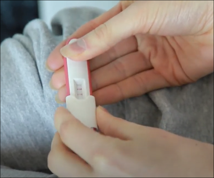 close up on a pregnancy test in a person's hands.